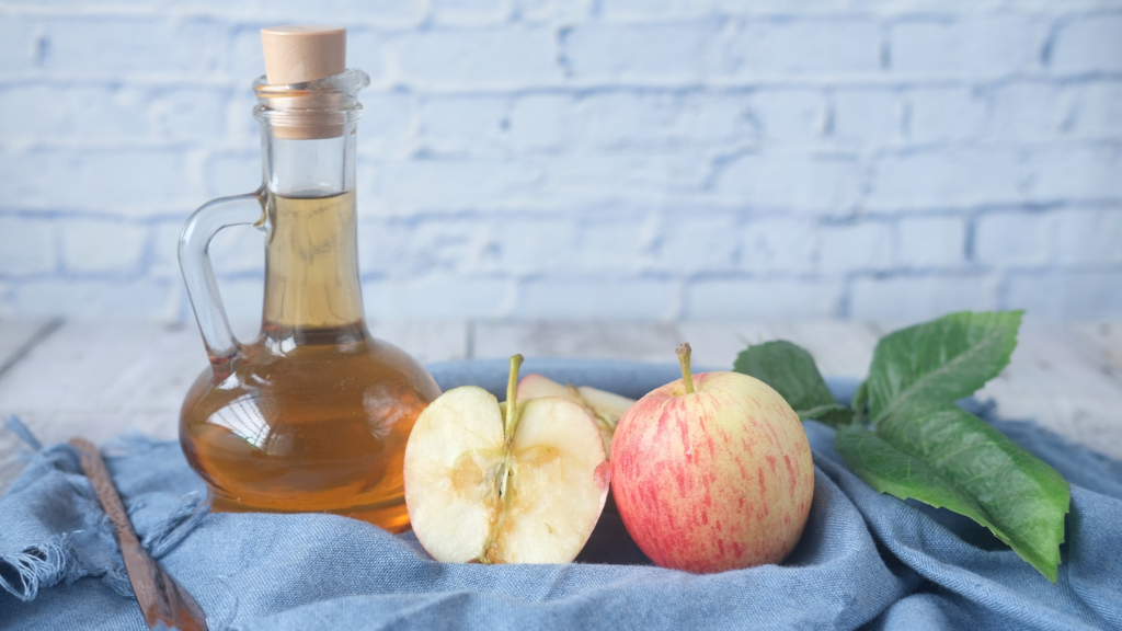 Bottle of apple cider vinegar and apples