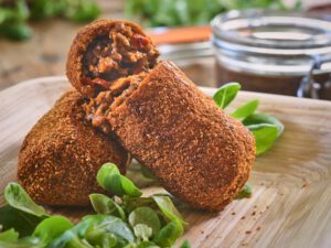 2 Vegan kroketten op een houten plank gemaakt van seitan