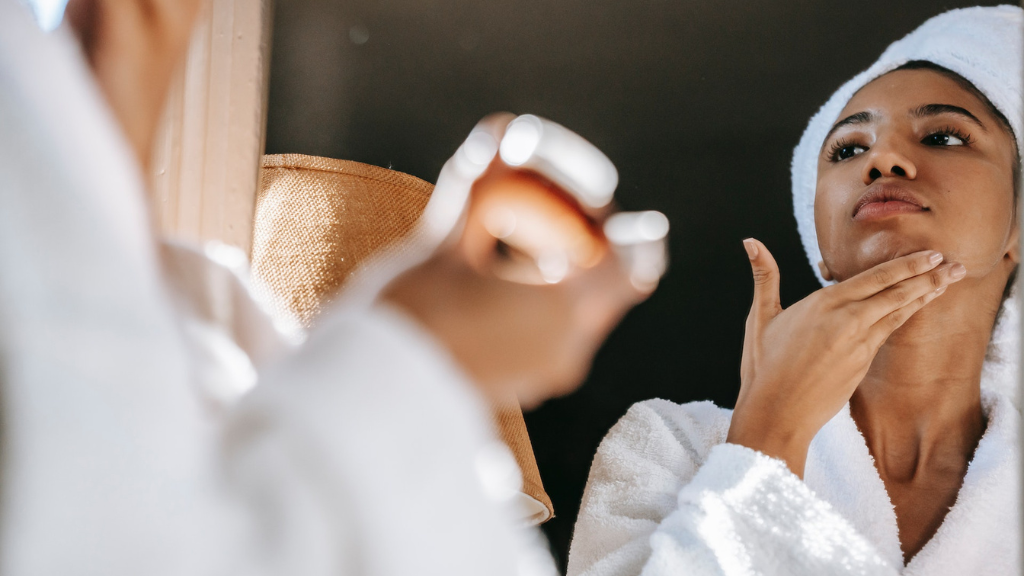 Vrouw smeert anti aging serum op hals en gezicht.