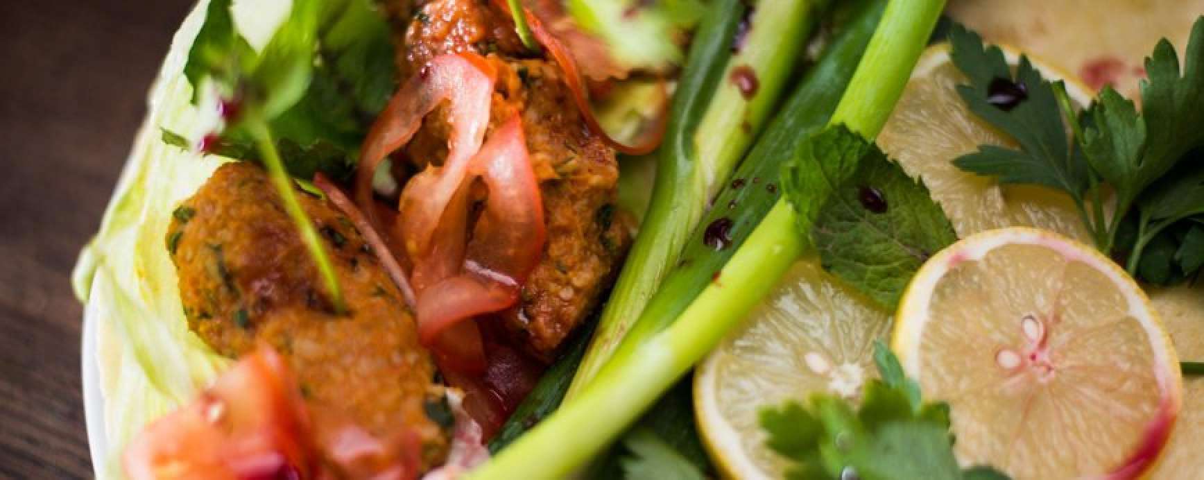Burrito with cig kofte made from bulgur wheat, and salad with pomegranate syrup
